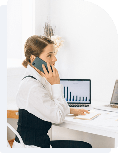 Image of a woman siting in office and talking on the phone.