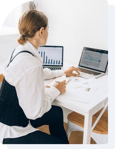 Image of a woman siting in the office and working on her laptop.